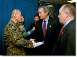 President George W. Bush and Laura Bush attend the U.S. Citizenship Ceremony for Marine Corps Mastery Gunnery Sgt. Guadalupe Denogean of Tucson, Ariz., at the National Naval Medical Center in Bethesda, Md., Friday, April 11, 2003. Pictured at far right, Eduardo Aguirre, Jr., Acting Director of the Bureau of Citizenship and Immigration Services, conducted the ceremony. White House photo by Eric Draper.