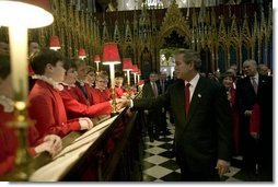 After listening to the Westminster Abbey Choir perform, President George W. Bush greets one of the younger choir members during his and Mrs. Bush's tour of the abbey Thursday, Nov. 20, 2003. White House photo by Eric Draper.